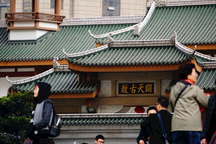 中式古建筑前的行人