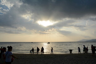 夕阳下海边的人群剪影