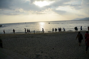 夕阳下热闹的海边沙滩