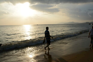 夕阳下的海边漫步身影