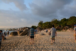 黄昏下的沙滩漫步人群