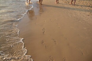 沙滩漫步的人群与海浪