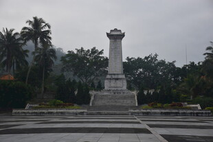 纪念碑矗立在绿植环绕处