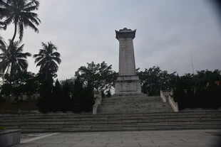 纪念碑矗立在绿植环绕处