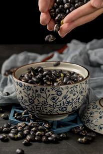 手撒黑豆于青花碗旁