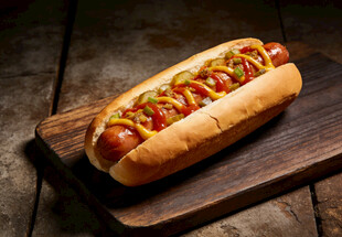 美味热狗置于木质砧板上