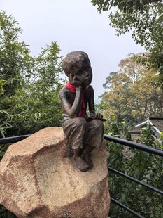 坐在石头上的孩童铜像