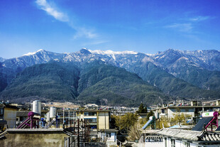 山城繁华与远山雪景相映