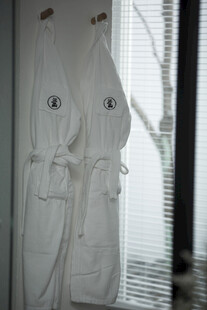 两件白色浴袍挂在窗边