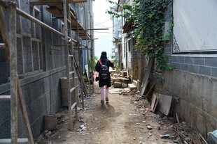 女孩独行于狭窄小巷