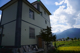 乡村旁的两层灰白住宅