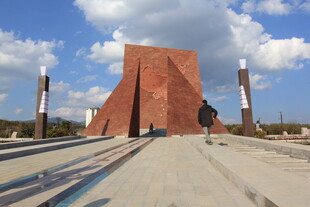 红色纪念碑矗立蓝天白云下