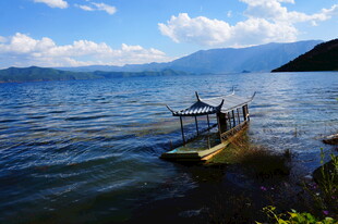 湖畔小船静泊于碧水蓝天