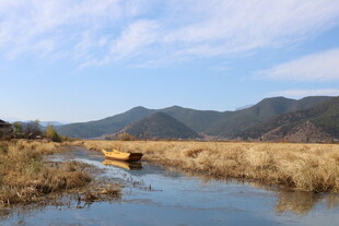 溪边孤舟伴远山美景