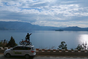 湖畔车旁的骑行者风景