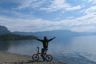 湖畔骑行者张开双臂赏景