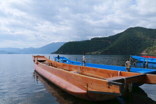 湖畔停泊的木船与蓝篷船