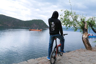 女子骑行赏湖畔美景