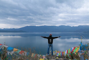 湖畔旅人张开双臂赏美景