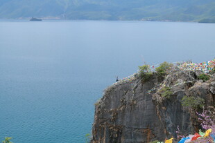 悬崖边的经幡与辽阔湖水