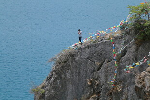 悬崖边的彩色经幡与人物