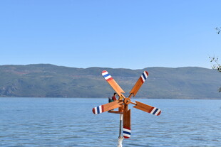 湖畔风车立于碧水蓝天间