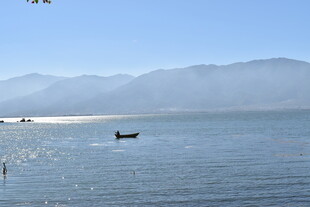 宁静海边小船与远山景色