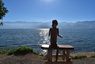 湖畔男子于桌前展臂赏景