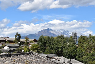 山间村落与远处巍峨雪山
