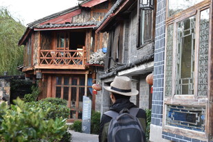 漫步古巷中的背包旅人