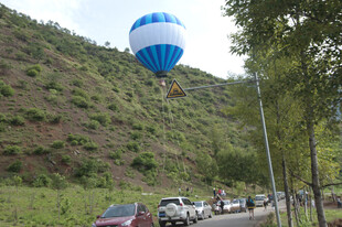 公路旁升空的蓝白热气球