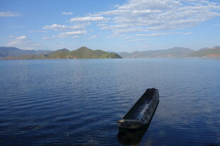 孤舟静泊于辽阔湖面上