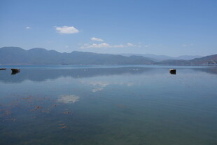 平静湖面映蓝天远山