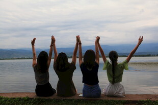 青春少女湖边高举双臂