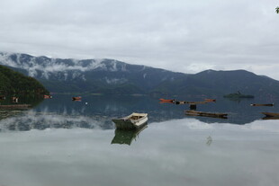 宁静湖面的孤舟与远山