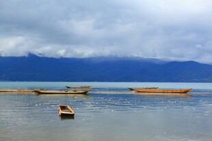 宁静湖面的孤舟与远山