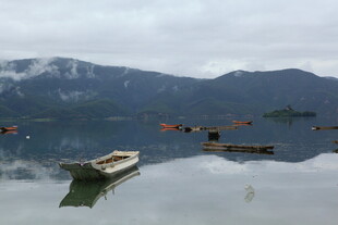 湖中小船与远处山峦景色