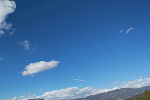 蓝天飘云下的远山景色