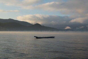 孤舟泛于山水云雾间