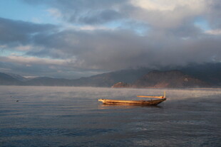 孤舟泛于山水云雾间