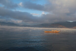 海上孤舟伴云雾美景