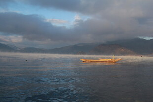 湖面上的孤舟与朦胧晨雾
