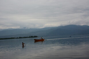 湖畔孤舟与漫步之人