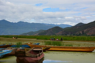 河畔停泊船只与远山美景