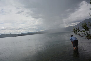 湖畔雨中漫步的孤独身影