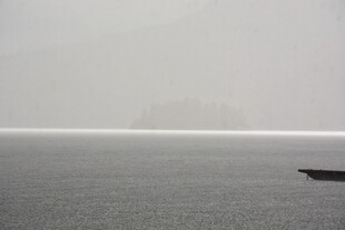 孤舟泛于雾霭水面