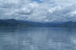 宁静湖面与远方山峦云雾