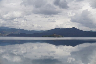 平静湖面映山峦与云景