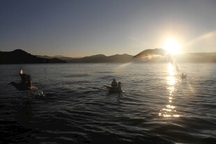 夕阳下水中嬉戏的人们