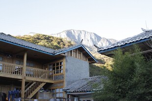 山间木屋与远处巍峨雪山